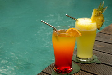 Summer refreshment drinks, drinking glasses next to the pool edge