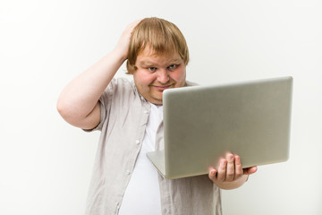 Caucasian plus size man holding a laptop being shocked, she has remembered important meeting.