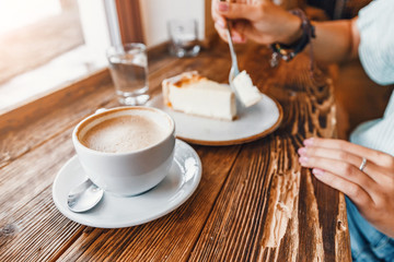 beautiful young woman eating cake and drinking coffee in retro cafe