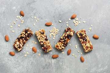 Granola bars on a grey rustic background. Super food, granola with nuts and cranberries. Top view,...