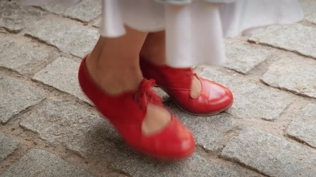 Man and woman dancing flamenco in park. Spanish people and traditional dance in Andalusia, Spain. Dancers performing traditional show in park. Couple and music arts. Close-up of female shoes