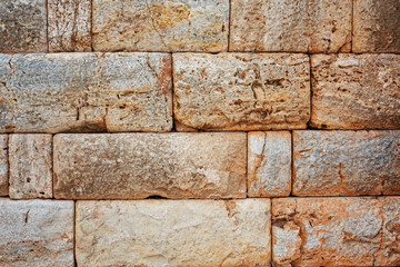 Texture of a stone wall made of large blocks. Elements of the building of ancient antiquity.