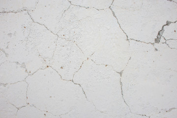Texture of a white painted wall in cracks