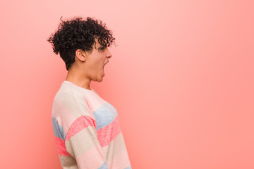 Young mixed african american teenager woman shouting towards a copy space © Asier
