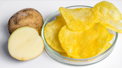 Potato chips in glass and potato bowl isolated on white background