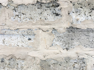 Old gray brick wall covered with concrete. Abstract background.