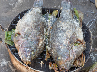Two fish were stuffed herbs in the stomach, then sprinkle salt on the skin, then grilled by fire until cooked to eat.