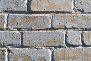 Close-up of an old painted peeling cracked brick