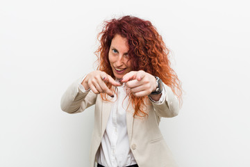 Young natural redhead business woman isolated against white background cheerful smiles pointing to front.