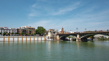 Obraz premium Puente de Isabel II por Puente de Triana, bridge connecting the Triana neighborhood with the historic centre of the city crossing the Guadalquivir River, Seville, Andalusia, Spain