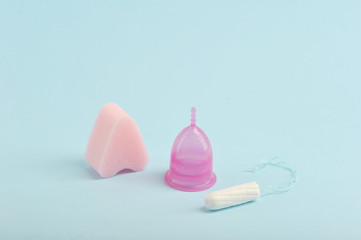 Soft tampon for playing sports on critical days, the menstrual cup and tampons are classic. Reliable protection of a new generation for modern women. Blue background. 