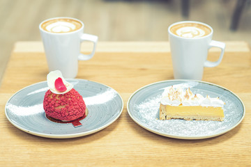 Close up a two different pieces of cake and two cups of coffee on the table at cafe. Dessert with coffee on the table in cafe.