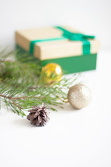 New Year and Christmas background for cards, greetings, website, advertising. Pine branches, Christmas balls, pine cone and gift box. Selective focus