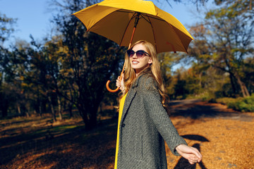 Beautiful girl posing in autumn Park with orange leaves