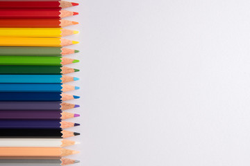 Fototapeta premium Colored pencils on white paper background