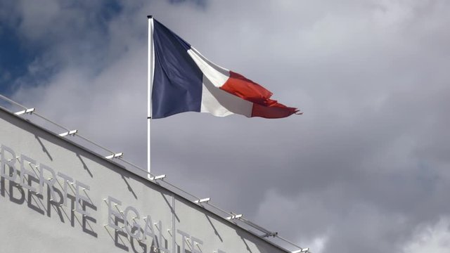 Waving flag on top of a town hall in La Grande Motte, France. Slow motion shot