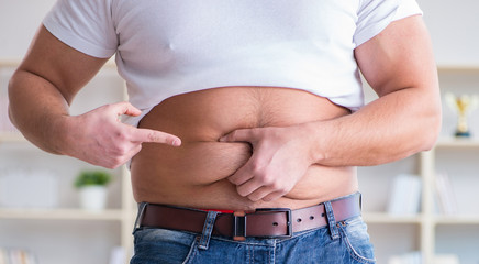 Man suffering from extra weight in diet concept