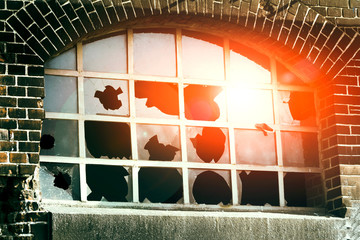broken glass reflecting the blue sky and red sun. Old house architecture.