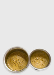 South Indian coffee served in steel glasses - white background with space for text
