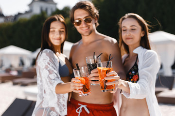 Group of friends having a cocktail on the beach