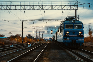 Fototapeta premium Train moves on tracks in evening.Railway transportation, passenger train.