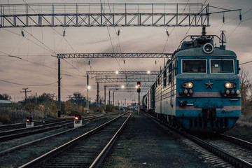 Fototapeta na wymiar Train moves on tracks in evening.Railway transportation, passenger train.