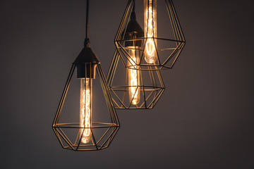 vintage retro incandescent lamps in modern chandeliers on a gray background