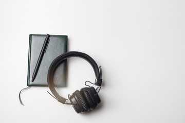 Pen on a notepad with a headphone on