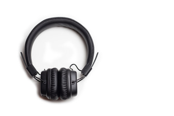 Fototapeta premium Black wireless headphones on a white background, top view
