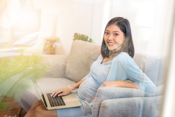 Obraz premium beauty happy Asian pregnant woman with big belly using computer - pregnancy, motherhood, people and expectation concept.