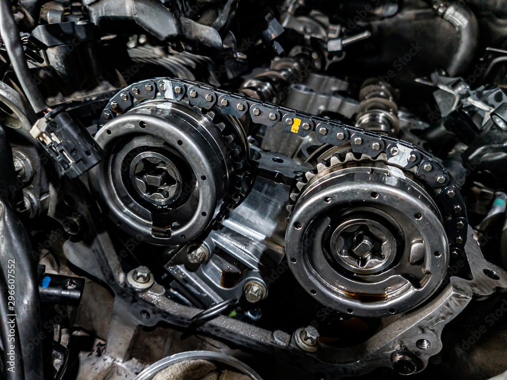 Sticker Close-up on a disassembled engine with a view of the gas distribution mechanism, chain, gears and tensioners during repair and restoration after a breakdown. Auto service industry.