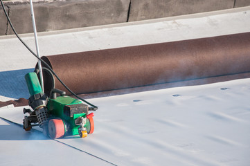 Construction device for installing waterproofing materials on the roof