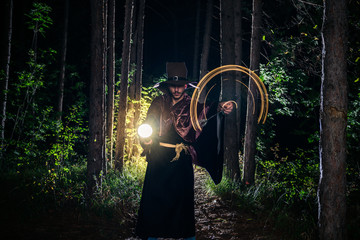Young male cosplayer wearing sorcerer robes in the forest