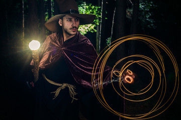 Young wizard showing magic on halloween night with his magic wand