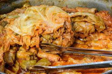 Freshly cooked large portion of cabbage rolls with meat and cabbage, a traditional Romanian food called sarmale cooked at a food market