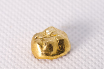 Zahngold: Goldzahn / Krone auf weißem Stoff
