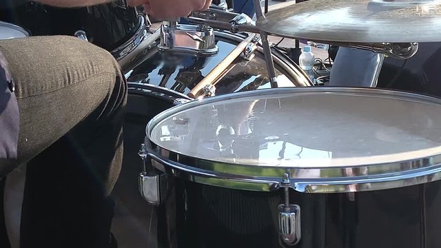 A drummer performing on his Drumset, playing on drum kit close up