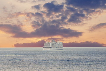 Luxury cruise ship sunset in blue sea with clouds