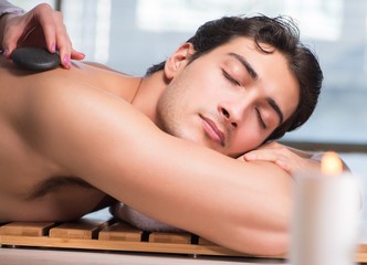 Obraz na płótnie Canvas The young handsome man during spa procedure
