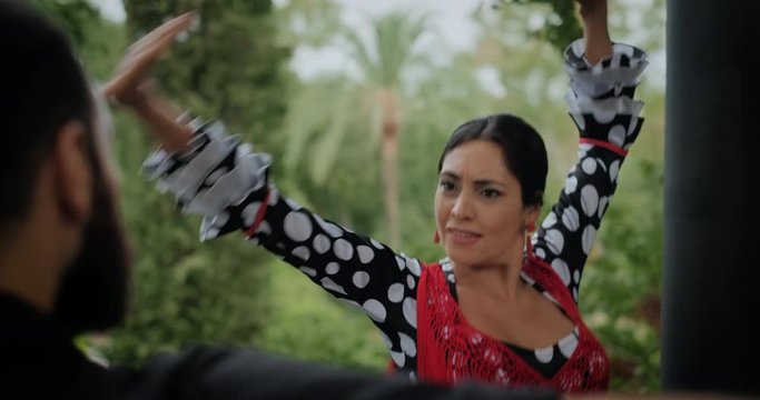 Man and woman dancing flamenco in park. Spanish people and traditional dance in Andalusia, Spain. Dancers performing traditional show in park. Couple and music arts