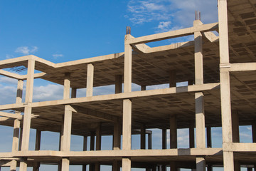 concrete structure of building under construction, building construction site work from concrete, concrete formwork, construction of the building, building construction site work against blue sky