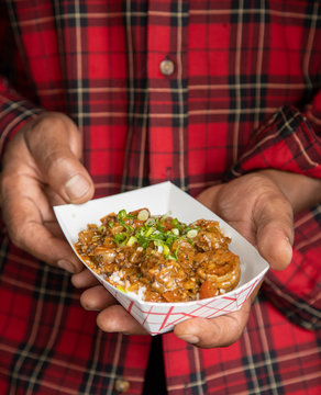 Holding shrimp creole close with two hands vertical