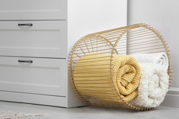 Basket with soft plaid near commode in room