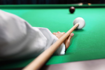 Young woman playing billiard indoors, closeup - obrazy, fototapety, plakaty