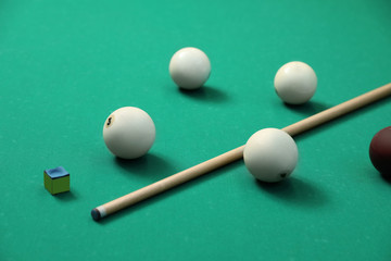 Billiard balls, cue and chalk on table