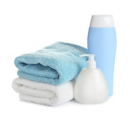 Obraz na płótnie Canvas Folded soft towels and toiletries on white background