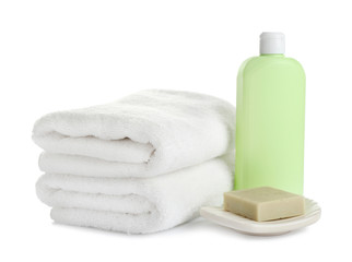 Fototapeta na wymiar Folded soft towels and toiletries on white background