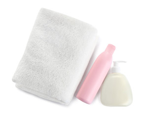 Obraz na płótnie Canvas Folded soft towel and toiletries on white background, top view