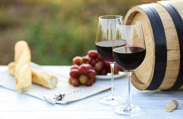 Composition with barrel of wine and products on table outdoors, closeup
