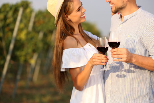 Happy couple holding glasses of wine outdoors, closeup view - Powered by Adobe